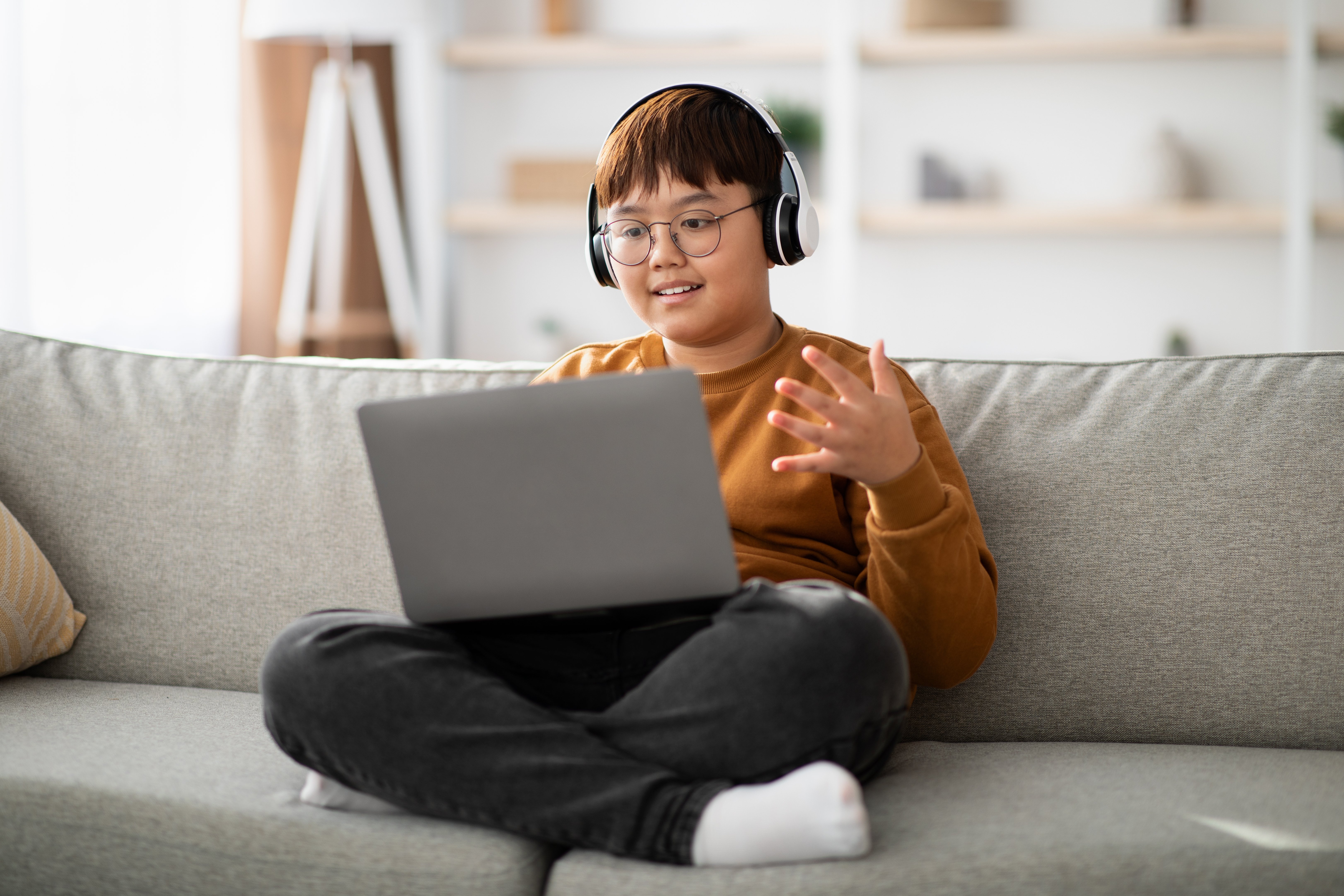 Niño en una laptop estudiando con música